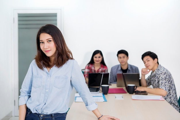 La bonita líder de negocios está delante de su equipo.