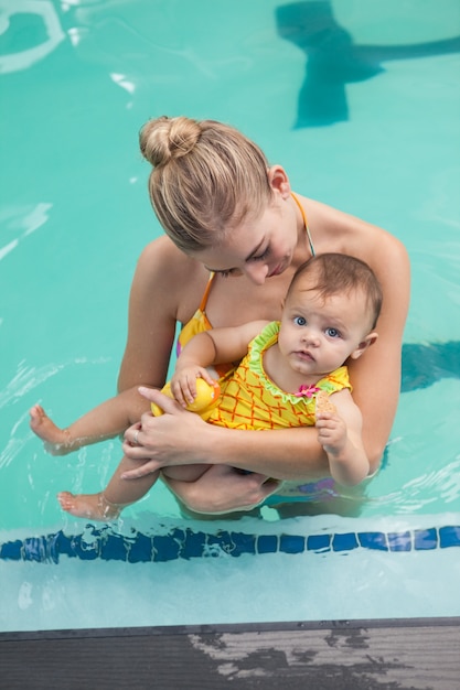 Bonita madre y bebé en la piscina en el centro de ocio
