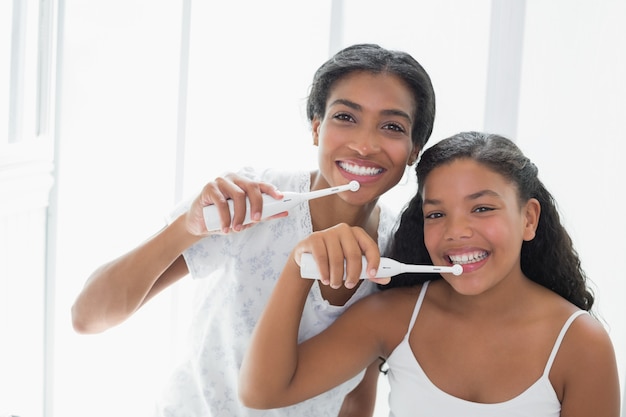 Bonita madre cepillándose los dientes con su hija