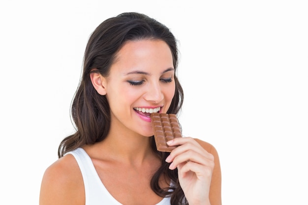 Bonita morena comiendo barra de chocolate
