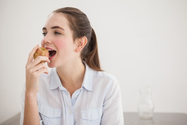 Bonita morena comiendo una manzana