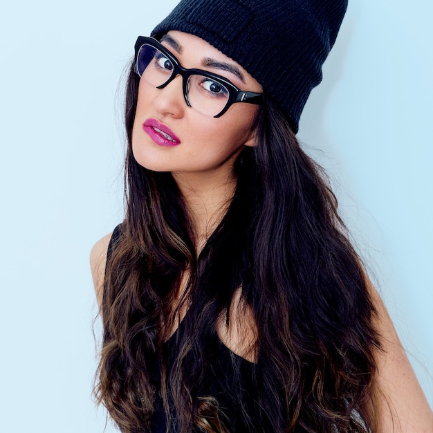 Bonita morena con elegantes gafas y gorro