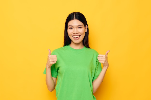 Bonita morena posando en camiseta verde emociones copyspace fondo amarillo inalterado