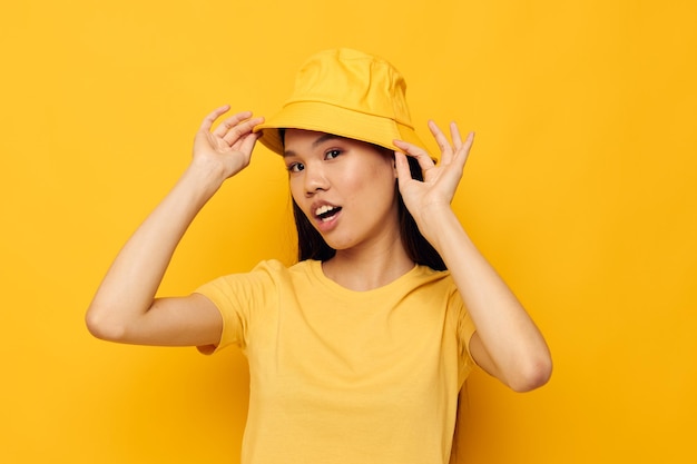 Bonita morena con un sombrero amarillo posando emociones modelo de estudio inalterado