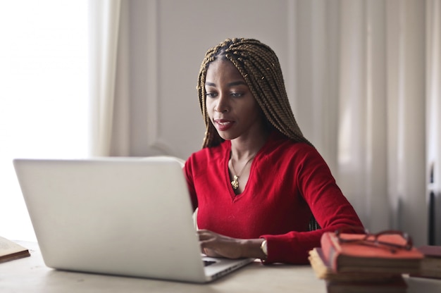 Bonita mujer afro trabajando en una computadora portátil