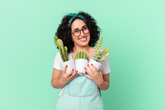 Bonita mujer árabe con cactus en macetas decorativas