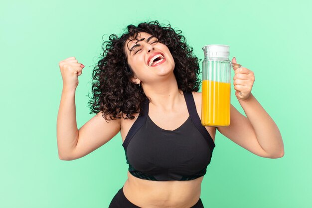 Bonita mujer árabe con jugo de naranja. concepto de desayuno saludable