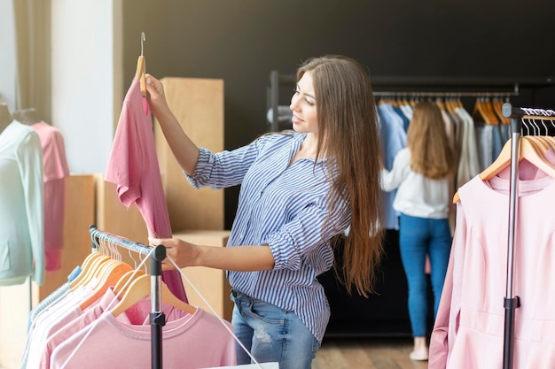 Bonita mujer caucásica mirando camiseta rosa, tiempo de compras