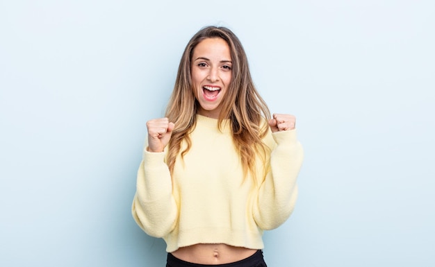 bonita mujer caucásica que se siente feliz, positiva y exitosa, celebrando la victoria, los logros o la buena suerte