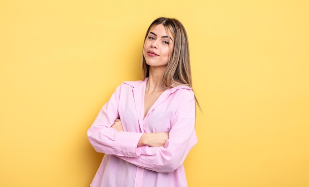 Bonita mujer caucásica riendo felizmente con los brazos cruzados, con una pose relajada, positiva y satisfecha