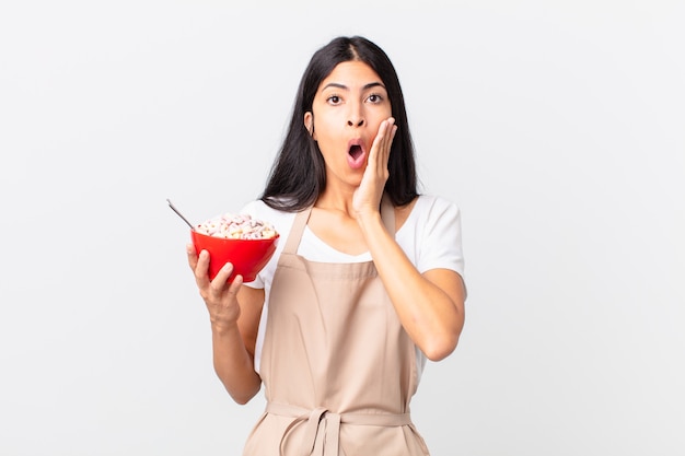 Bonita mujer chef hispana contra la pared de aislamientos