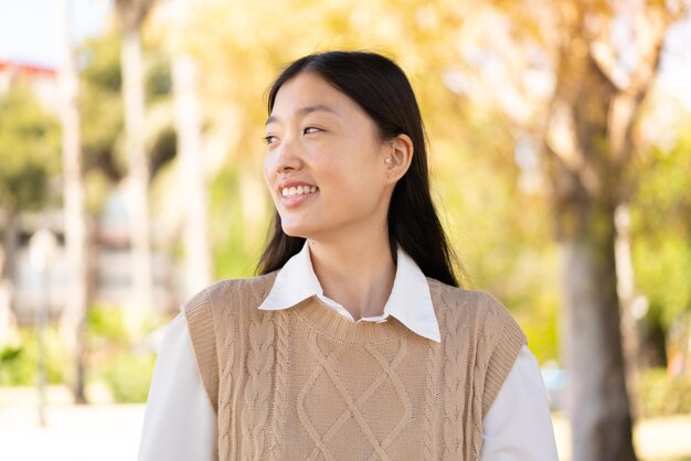 Bonita mujer china al aire libre con expresión feliz