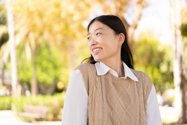 Bonita mujer china al aire libre con expresión feliz