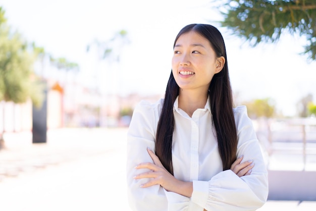 Bonita mujer china al aire libre feliz y sonriente