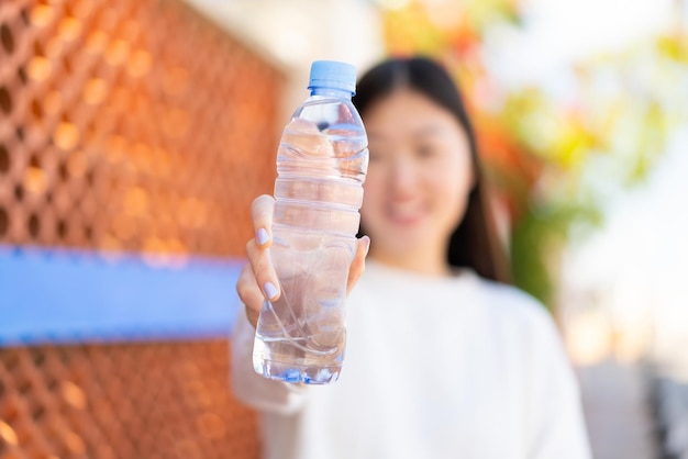 Bonita mujer china con una botella de agua al aire libre