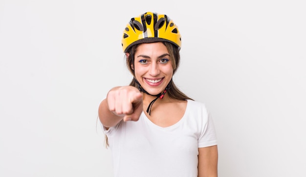 Bonita mujer hispana apuntando a la cámara eligiendo tu concepto de bicicleta