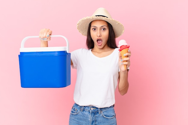 Bonita mujer hispana con un congelador portátil y un helado