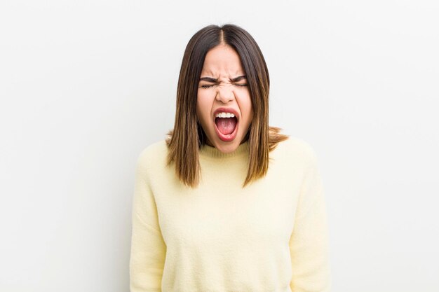 Bonita mujer hispana gritando agresivamente luciendo muy enojada frustrada indignada o molesta gritando no