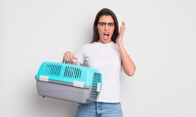 Bonita mujer hispana gritando con las manos en el aire. concepto de transporte de mascotas