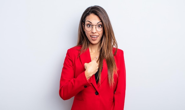 Bonita mujer hispana mirando consternado y sorprendido con la boca abierta, apuntando a sí mismo. concepto de empresaria