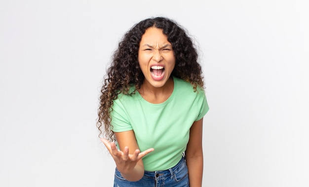 Bonita mujer hispana que parece enojada, molesta y frustrada gritando wtf o qué te pasa