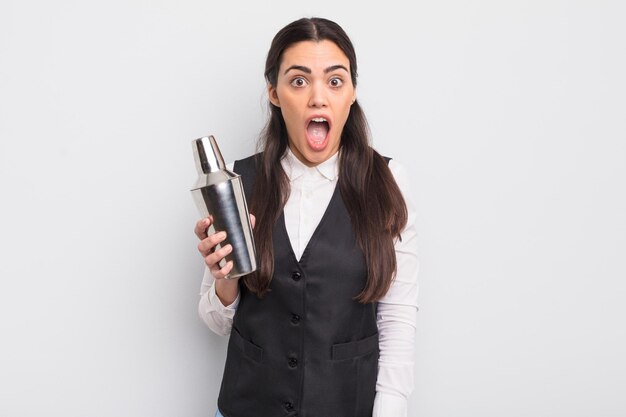 Bonita mujer hispana que parece muy sorprendida o sorprendida del concepto de cóctel de barman