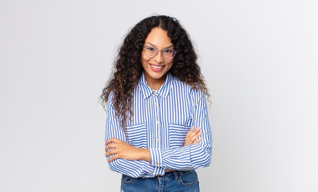 Bonita mujer hispana que parece una triunfadora feliz, orgullosa y satisfecha sonriendo con los brazos cruzados