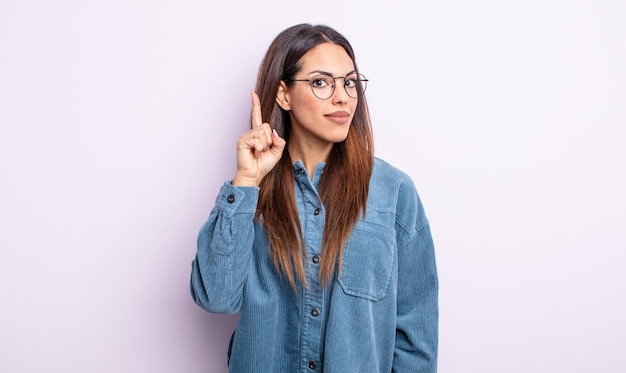 Bonita mujer hispana que se siente como un genio levantando el dedo con orgullo en el aire después de darse cuenta de una gran idea, diciendo eureka