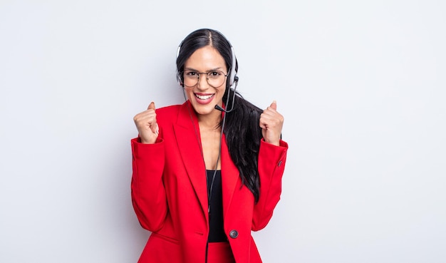 Bonita mujer hispana que se siente conmocionada, riendo y celebrando el éxito. concepto de telemarketing