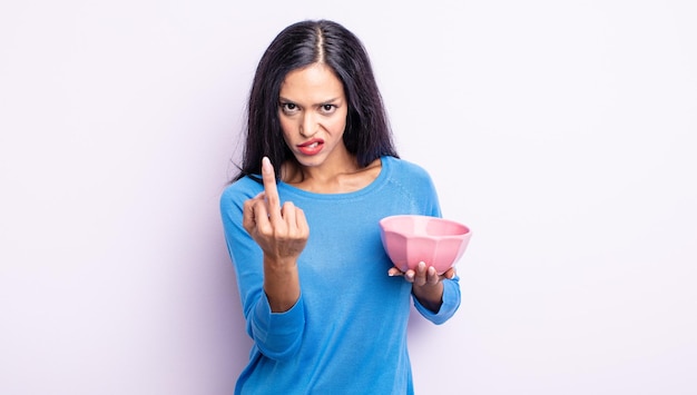 Bonita mujer hispana que se siente enojada, molesta, rebelde y agresiva. concepto de tazón vacío