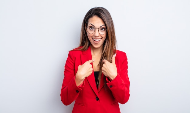 Bonita mujer hispana que se siente feliz y apunta a sí misma con un emocionado. concepto de empresaria