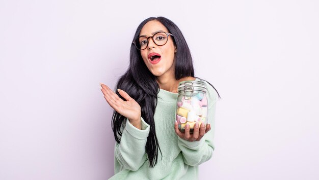 Bonita mujer hispana que se siente feliz y asombrada por algo increíble concepto de caramelos de gelatina