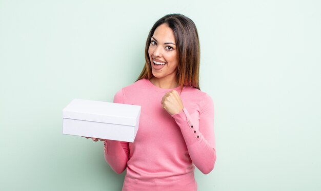 Bonita mujer hispana que se siente feliz y enfrenta un desafío o celebrando. concepto de embalaje de caja blanca