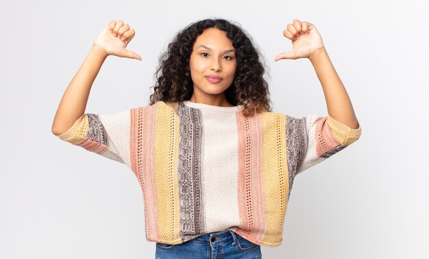 Foto bonita mujer hispana que se siente orgullosa, arrogante y segura, que parece satisfecha y exitosa, apuntando a sí misma