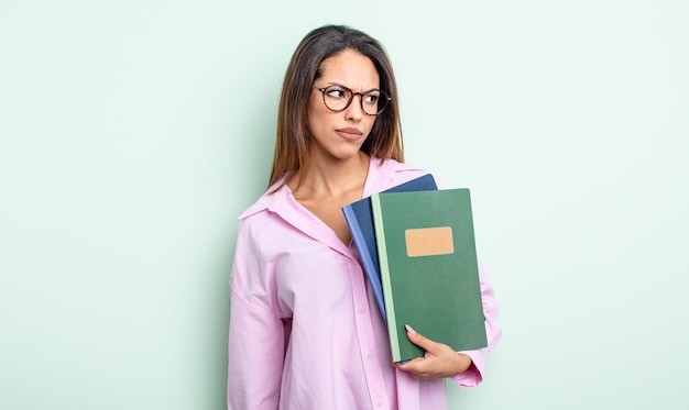 Bonita mujer hispana que se siente triste, molesta o enojada y mira hacia un lado. concepto de cuadernos