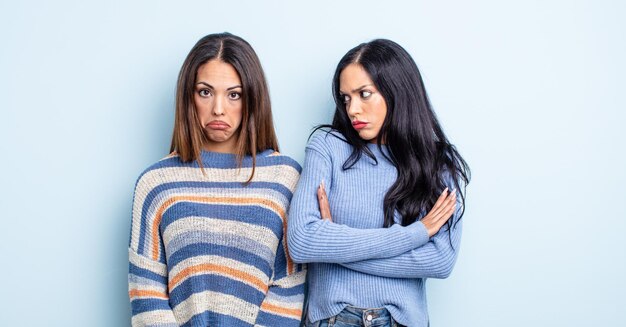 Bonita mujer hispana que se siente triste y quejumbrosa con una mirada infeliz y llorando. concepto de pareja de amigos