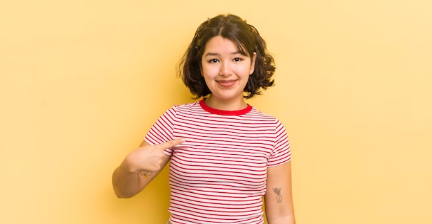 Bonita mujer hispana que se ve orgullosa, confiada y feliz sonriendo y apuntándose a sí misma o haciendo el signo número uno