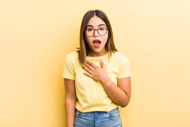 Bonita mujer hispana sintiéndose conmocionada y sorprendida sonriendo tomando de la mano feliz de ser la indicada o mostrando gratitud