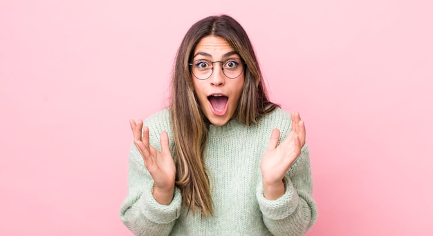 Bonita mujer hispana sintiéndose feliz emocionada sorprendida o sorprendida sonriendo y asombrada por algo increíble