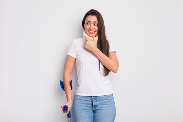 Bonita mujer hispana sonriendo con una feliz expresión de confianza con la mano en la barbilla y el concepto de lesión física