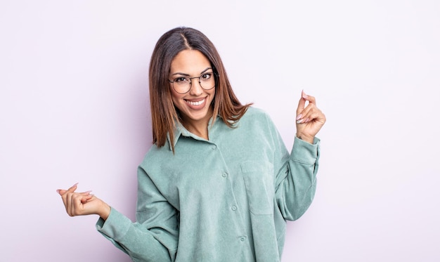 Bonita mujer hispana sonriendo, sintiéndose despreocupada, relajada y feliz, bailando y escuchando música, divirtiéndose en una fiesta