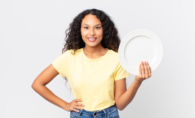 Bonita mujer hispana sosteniendo un plato limpio vacío