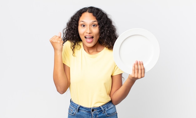 Bonita mujer hispana sosteniendo un plato limpio vacío