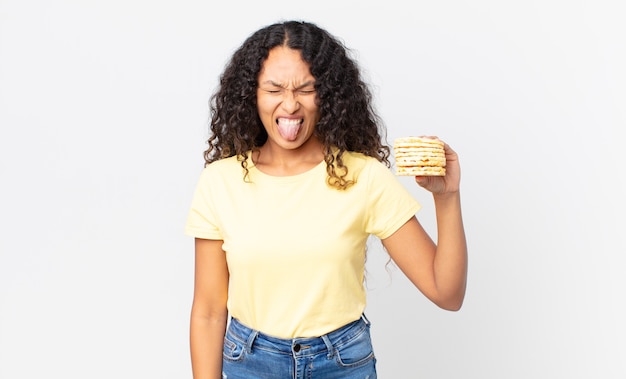 Bonita mujer hispana sosteniendo una torta de dieta de arroz