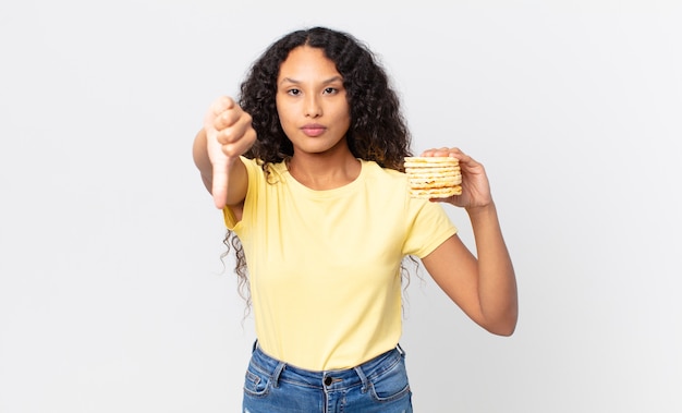 Bonita mujer hispana sosteniendo una torta de dieta de arroz