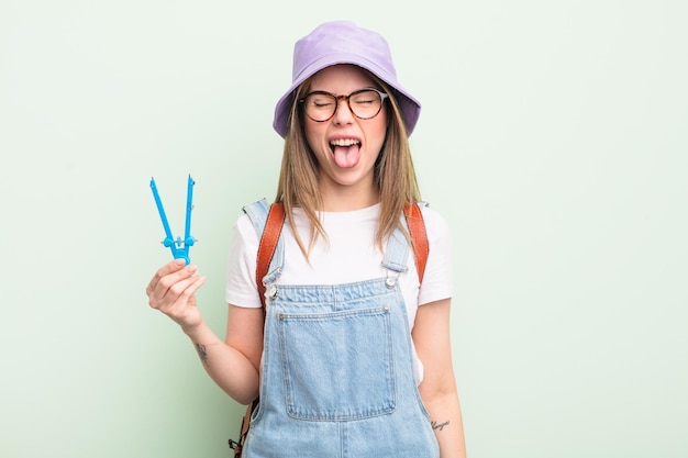 bonita mujer joven con actitud alegre y rebelde, bromeando y sacando la lengua. concepto de estudiante