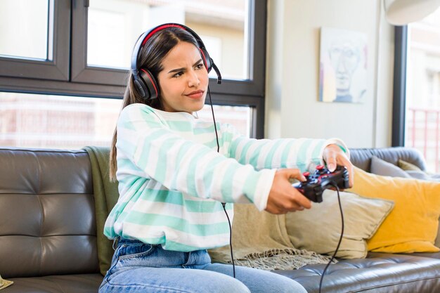 Foto bonita mujer latina jugando con el concepto de jugador de auriculares y controlador