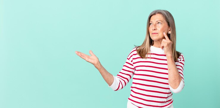 Foto bonita mujer de mediana edad sonriendo felizmente y soñando despierto o dudando