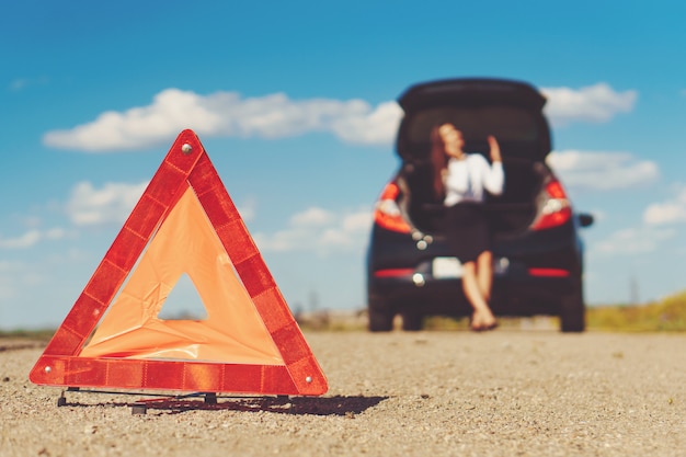 Foto bonita mujer de negocios sentado en el baúl del auto