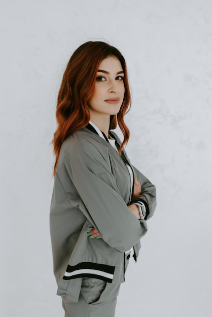 Bonita mujer de negocios en traje gris con tablet aislado sobre fondo blanco.